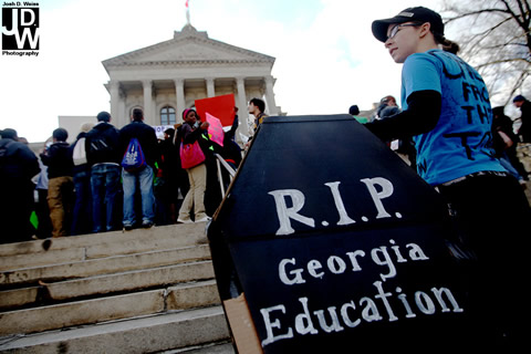 student protestor holds a casket reading RIP Georgia Education