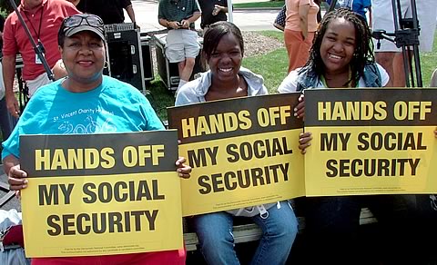Women hold signs reading HANDS OFF SOCIAL SECURITY